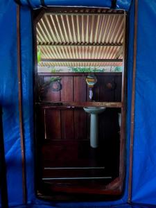 a bathroom in a blue tent with a sink at Hacienda Rio Oro in Agua Buena