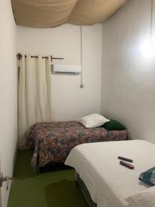 a small room with two beds and a window at Hotel Chulamar, Piscina y Restaurante in Escuintla