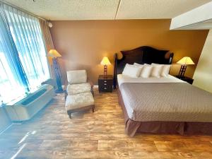 una camera con letto, sedia e vasca di Eureka Springs Heritage Motel a Eureka Springs
