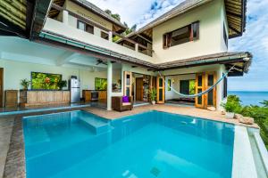 a villa with a swimming pool in front of a house at White Azure Villa Koh Phangan in Than Sadet Beach