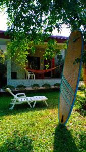 a surfboard sitting in the grass in front of a house at Nananuira Apartment and Room in Khao Lak