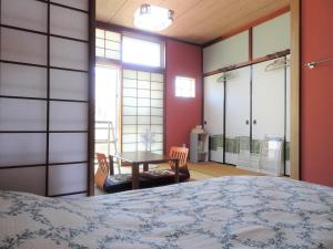 糸满民宿糸满别邸旅馆的卧室配有床、桌子和窗户。
