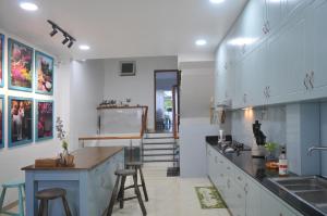 a kitchen with a sink and a counter with stools at 29-House in Cà Mau