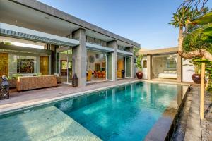 an image of a swimming pool in front of a house at Aramanis Villas in Seminyak