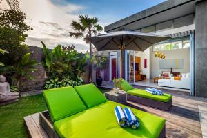 a living room with a green couch and an umbrella at Aramanis Villas in Seminyak