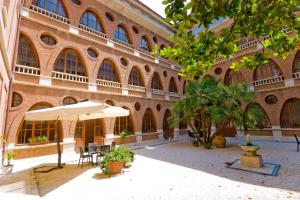 ein Gebäude mit Tischen und Sonnenschirmen davor in der Unterkunft San Francesco Hotel in Loreto