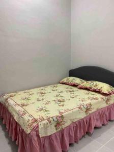 a bedroom with a bed with a bedspread on it at afza Homestay Paka A in Paka