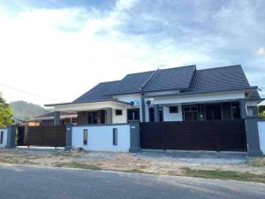 a house with a fence in front of it at afza Homestay Paka A in Paka +2 photos