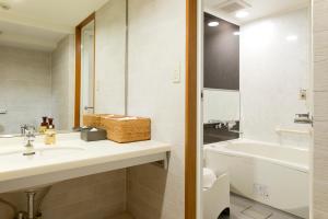 a bathroom with a sink and a toilet and a tub at Kadoya Hotel in Tokyo