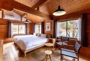 a bedroom with a bed and a table and chairs at Hanare no Yado Hanagokoro in Minamioguni