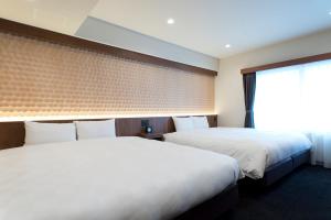 a hotel room with two beds and a window at Kadoya Hotel in Tokyo