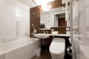 a bathroom with a toilet and a sink and a tub at Kadoya Hotel in Tokyo