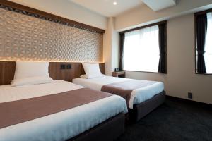 a hotel room with two beds and a window at Kadoya Hotel in Tokyo