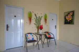 a table with two chairs and a vase with flowers at Urbanview Hotel Jogja City Mall in Yogyakarta