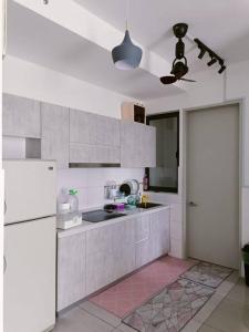 a kitchen with white cabinets and a white refrigerator at The CLIO 2 residences, beside ioi city mall, opposite hospital Serdang, beside Uniteen and UPM, Putrajaya in Putrajaya