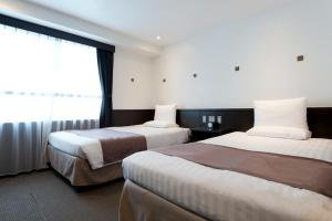 a hotel room with two beds and a window at Kadoya Hotel in Tokyo