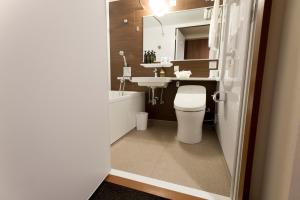 a bathroom with a white toilet and a sink at Kadoya Hotel in Tokyo