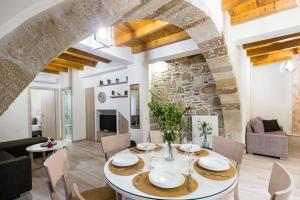 a dining room and living room with a stone wall at Petros Luxury Traditional House - Villa in Kissamos