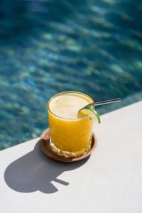 a drink on a plate next to a pool at Anchor Bed & Bread in Kuta Lombok