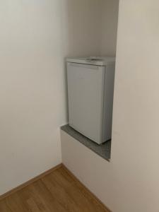 una pequeña nevera blanca en una esquina de una habitación en FELIX LIVING 1, Modern & cozy, Netflix, Smart TV en Passau