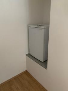 a small white refrigerator in a corner of a room at FELIX LIVING 1, Modern & cozy, Netflix, Smart TV in Passau