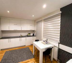 a kitchen with white cabinets and a white table at Stan na dan Nina - Pale Centar in Pale