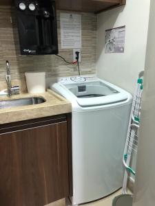 a washing machine in a kitchen with a sink at Park Veredas do Rio Quente Flat 518 - Com acesso ao RIO in Rio Quente