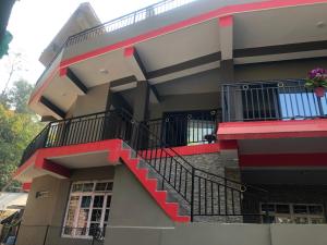 a building with a staircase in front of it at Maple Homestay in Kalimpong