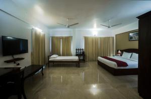 グルヴァイアールにあるHotel Guruvayur Darshanのベッド2台とテレビがあるホテルの部屋 +37枚の写真
