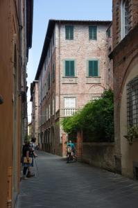 Un gruppo di persone che camminano in un vicolo di Le Antiche Scale a Lucca