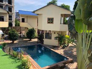 uma villa com piscina em frente a uma casa em Sofinny Motel 2 em Sihanoukville