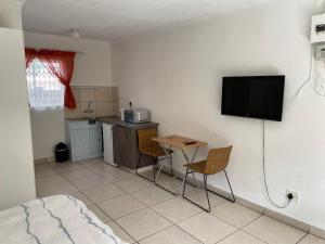 una camera con tavolo e televisore a parete di La Fiance Village a Polokwane Altre 11 foto