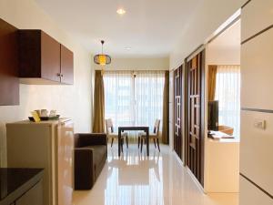 a kitchen and living room with a couch and a table at The Empire Nimman in Chiang Mai