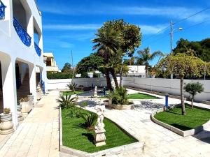 a courtyard of a building with palm trees and grass at VILLA LEA in Torre dell'Orso