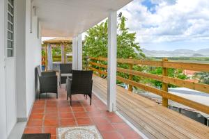 a porch with a table and chairs and a view at Suite jacuzzi et vue panoramique - BED AND COFFEE AIRPORT in Ducos