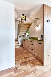 a kitchen with wooden cabinets and a staircase at La Suite in Chiroubles