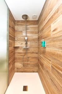 La salle de bains est pourvue de murs en bois et d'une cabine de douche. dans l'établissement La Suite, à Chiroubles