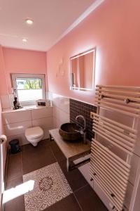 een badkamer met een wastafel, een toilet en een raam bij Timeout Namaste in Ellar