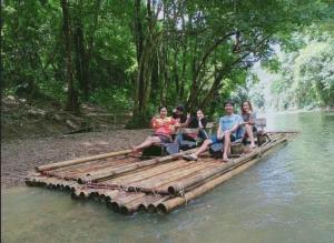 un grupo de personas sentadas en una balsa de bambú en el agua en Billion Views Khaosok Homestay, en Khao Sok