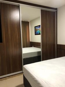 a hotel room with two beds and a mirror at Park Veredas do Rio Quente Flat 518 - Com acesso ao RIO in Rio Quente