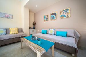 a living room with two beds and a table at Iro City and Beach Boutique Homes in Chania Town