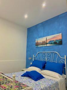 1 dormitorio con 1 cama con pared azul en Holiday house Lual en Agerola
