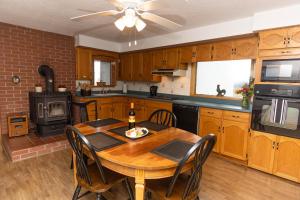 a kitchen with a wooden table with chairs and a ceiling fan at Farmhouse PEC in Hillier