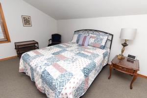 a bedroom with a bed with a quilt on it at Farmhouse PEC in Hillier