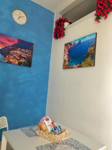 une chambre avec une table et une horloge sur un mur dans l'établissement Holiday house Lual, à Agerola