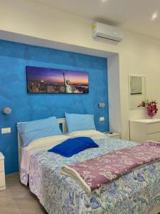 1 dormitorio con una pared azul y 1 cama en Holiday house Lual en Agerola