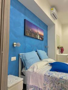 1 dormitorio con una pared azul y 1 cama en Holiday house Lual, en Agerola