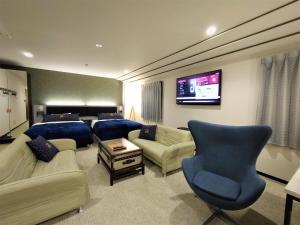 a living room with couches and a tv and a couch at Green Rich Hotel Matsue Station Across - Artificial hot spring Futamata Yunohana in Matsue