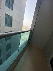 a balcony in a building with a view of the ocean at Lovely 1-bedroom Apartment with free Parking on premises in Ajman 