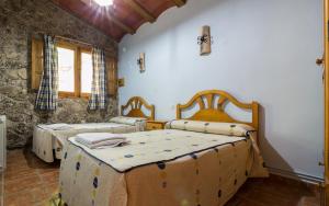 a bedroom with two beds and a window at Casas Rurales Los Enebros Nerpio in Nerpio